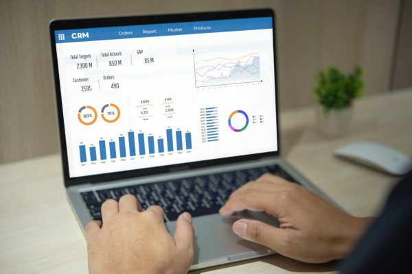 Man using computer laptop software with graphs and charts showing sales data. CRM Customer Man using computer laptop software with graphs and charts showing sales data. CRM Customer